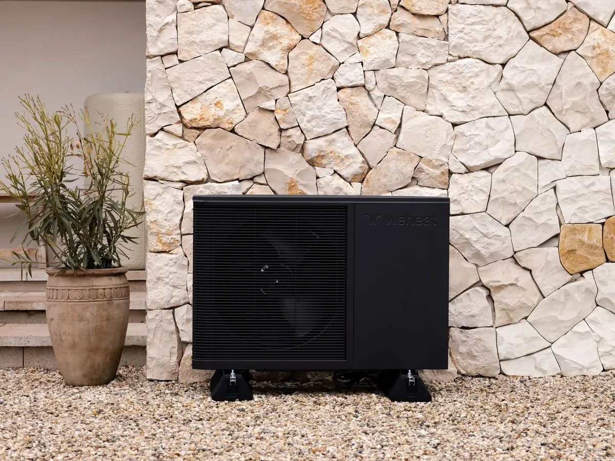 Weheat Flint warmtepomp tegen een stenen muur
